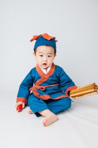 古装悬疑电视剧海报，主角身着华服立于宫廷廊柱间，烛光昏黄氛围神秘
